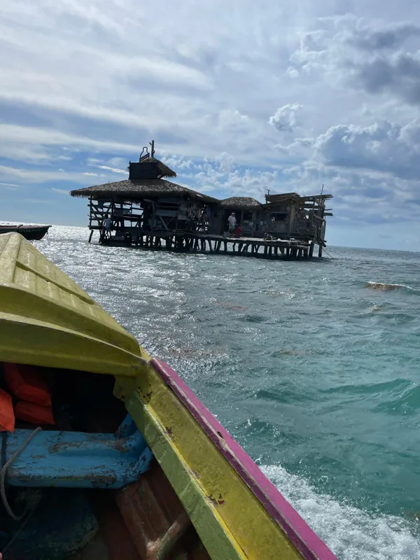 The offshore wooden bar seen over the bow of a small boat