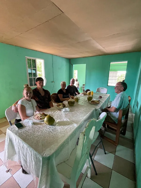 Guests sharing a meal around tables in a turquoise-painted restaurant