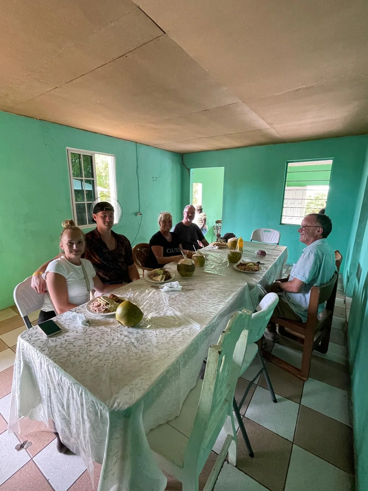 Guests sharing a meal around tables in a turquoise-painted restaurant